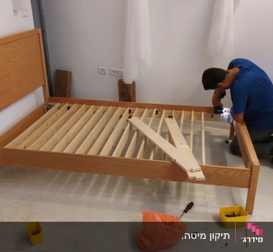 נגר מרכיב מיטה מעץ עם מברגה חשמלית